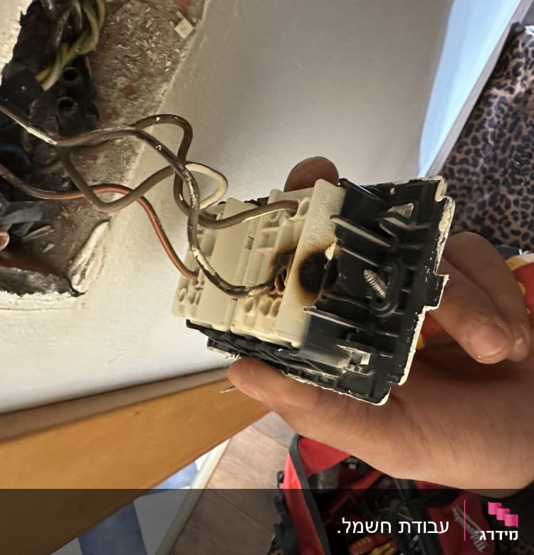 חוטי חשמל מחוברים לשקע חשמלי מפורק